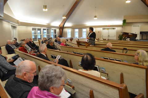 Adults sitting in pews studying the Bible